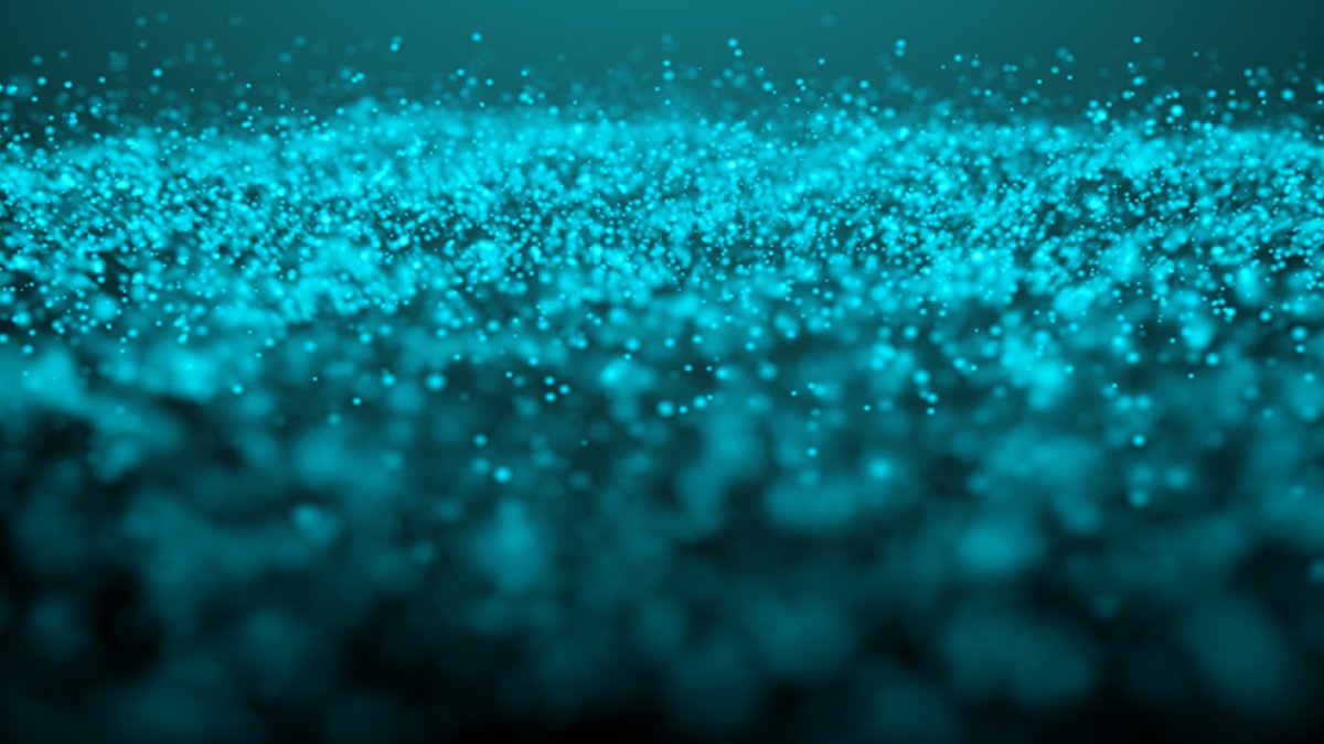 A glowing teal glitter cloud on a dark empty background